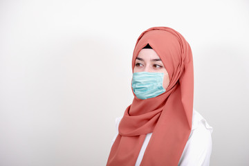 Muslim girl wearing surgical mask for protection. Hijab woman take a mask for coronavirus or COVID-19 epidemic or pandemic