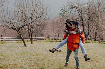 Naklejka na ściany i meble Loving couple walking on the mountain outdoors. Man and woman travel together. Couple traveler enjoys nature, hugs,