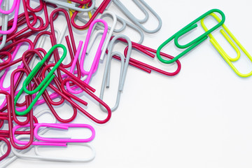 Multicolored paper clips on a white background with space for text