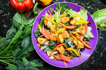 Fresh colored salad with bell peppers, spinach, onion and boneless chicken