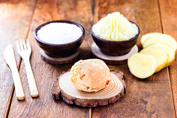 Vegan cheese bread, made without animal products, with ingredients on the side, tapioca and potatoes. Wooden sign with inscription: Vegan life.
