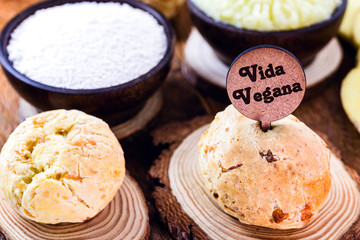 Vegan cheese bread, made without animal products, with ingredients on the side, tapioca and potatoes. Wooden sign with inscription: Vegan life.