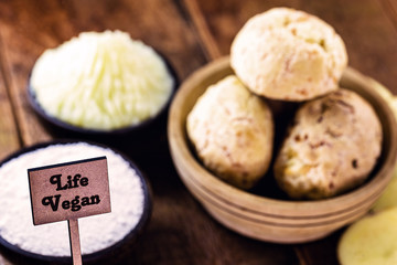 wooden sign written vegan life on defocused rustic background with organic food