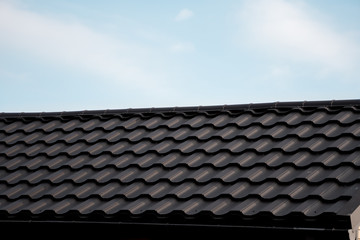 Brown metal tile roof. Roof metal sheets. Modern types of roofing materials. Roof of the house, metal roof tile against the blue sky. Building.
