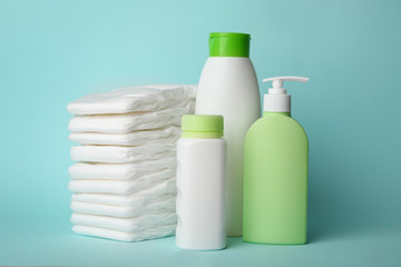 Diapers and baby accessories on light blue background