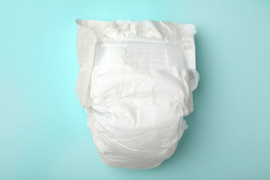 Baby diaper on turquoise background, top view