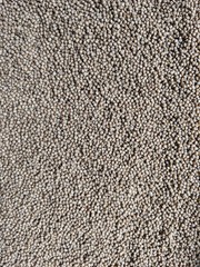Brown color fish pellets texture, fish feed background, top view