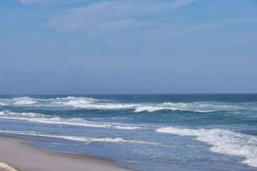 Heavy surf and whitecaps pound the fine sand beach at New Jersey's Island Beach State Park on a sunny but very windy day