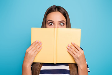 Closeup photo of crazy pretty lady hold planner copybook diary hiding half facial expression shy person big eyes book worm wear striped t-shirt isolated blue color background