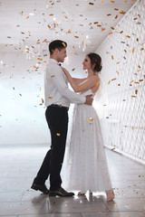 Happy newlywed couple dancing together in festive hall