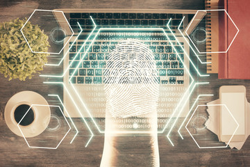 Obraz premium Finger print over computer on the desktop background. Top view. Double exposure. Concept of securitization.