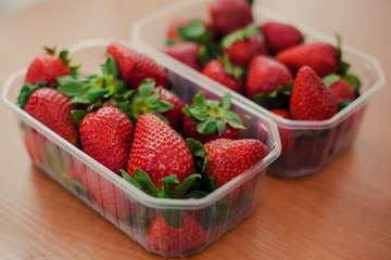 Red ripe fresh strawberry packed in plastic boxes at wholesale storage market for transportation and shipping export and import. Nutritious healthy strawberry diet food.