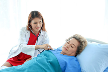 Asian doctor having checkup for a senior patient taken by soft focus technique