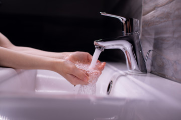 Clean kid hands by washing hands with soap