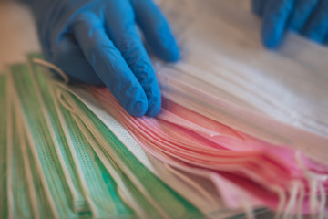 View of different coloured medical forensic face respirator mask, pink, green and blue masks.