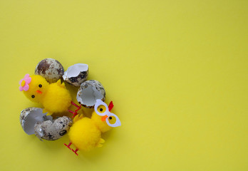 Fototapeta na wymiar Yellow toy chickens hatched from an egg, on a yellow background. space for text. easter concept