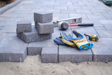 Paving stones pathway paving background. Installing tools on foreground