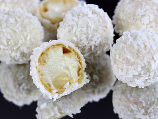 white delicious round candies sprinkled with coconut flakes with almond filling, tasty candies for children and women