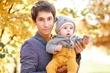 a young son is in the arms of his father