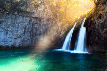 Fototapeta na wymiar Sunbeams on amazing waterfall in Plitvice lakes. Plitvice National Park, Croatia. Landscape photography