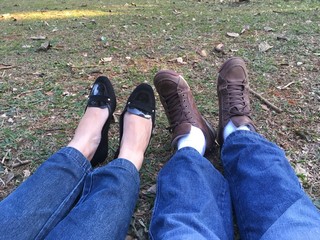 Sao Paulo, Sao Paulo, Brazil - April 29, 2018. Pair of female and male feet on a beautiful day in the park sitting on green grass.
