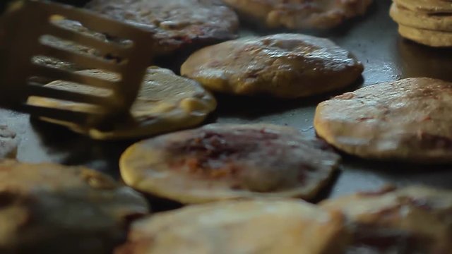 A close up of a large group of Pupusas (a traditional salvadoran dish) being prepared in an artisan way.