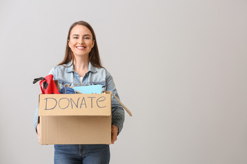 Volunteer with donations for orphans on grey background