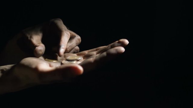 concept poverty, unemployment and crisis. beggar homeless man with dirty hands counts alms euros close-up