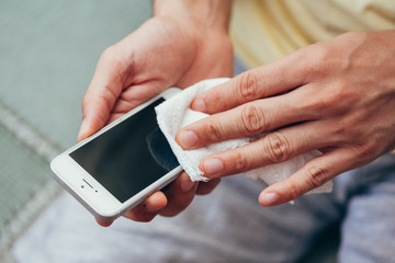 Cleaning smartphone to prevent coronavirus contamination. Precaution against Covid-19