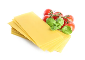 Foto op Plexiglas Uncooked lasagna sheets, tomatoes and basil on white background © New Africa