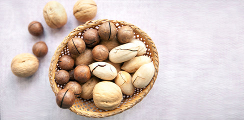 Nuts in a shell in a wicker bowl on a light background