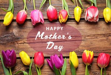 Flat lay composition with beautiful tulips and phrase HAPPY MOTHER'S DAY on wooden background