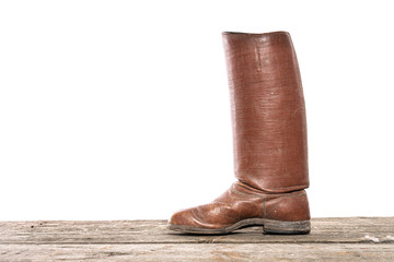 Old red leather high boot stands on the wooden floor
