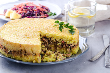 Rice dish with meat in the form of a cake, daily menu, a hearty lunch or dinner, close up on the table