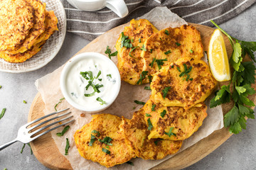 Potato Pancake with sour cream on a wooden board, top view