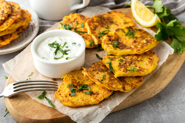 Potato Pancake with sour cream on a wooden board, close up
