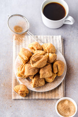 Sugar cookies on a plate, coffee mug, grey background, vertical format, top view