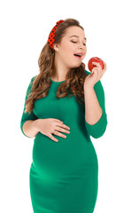 Beautiful pregnant woman with apple on white background