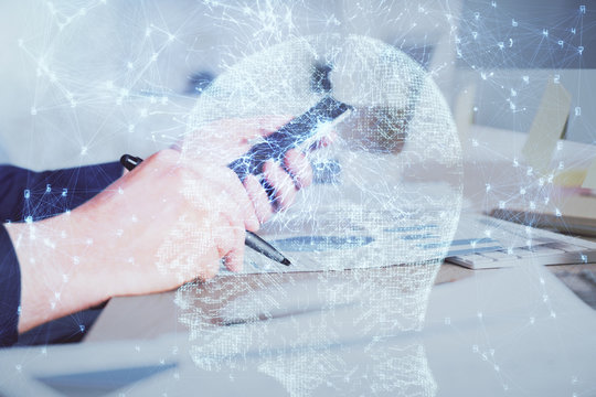 Double exposure of man's hand holding and using a digital device and brain hologram drawing. Data concept.