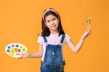 Cute little artist on color background