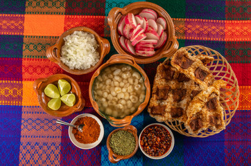 
Typical Mexican dish, white Pozole with chicken meat, and with the additional ingredients to put it, such as onion, oregano, radish, lemon, chili powder, beef greaves. 2