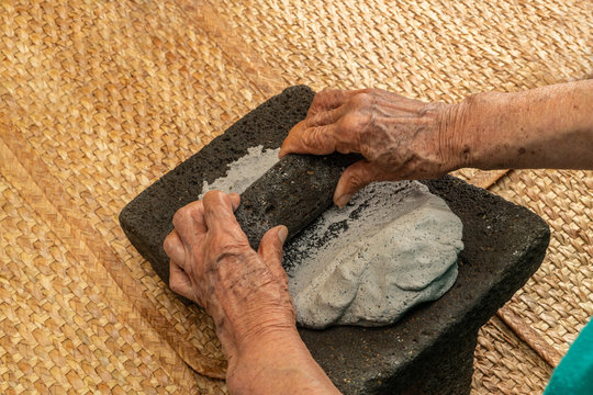Hands of an elderly woman, grinding dough in the metate for the elaboration of blue tortillas, which is a typical Mexican food, in the native peoples the women are in charge of doing that task 2