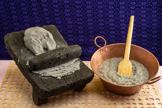 Metate with blue corn dough for making tortillas or masa atole, typical Mexican drink