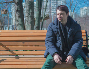 Depressive guy sitting on park benches.