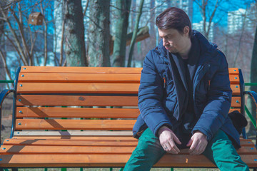 Depressive guy sitting on park benches.
