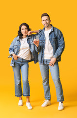 Fototapeta premium Stylish young couple with perfume on color background