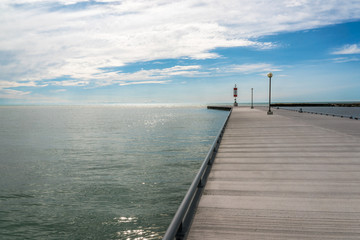 Fototapeta na wymiar The concrete pier on the sea/ocean with blue sky at dusk. background - copy space