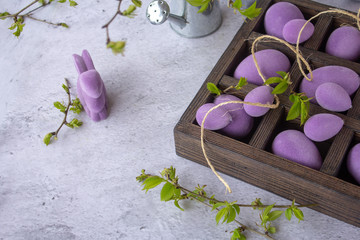 Marbled Easter eggs in a wooden box, on a bed of hay, with flowering branches of purple leaf plum tree