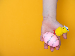 Fototapeta premium baby hand close up holding Easter eggs. Easter card