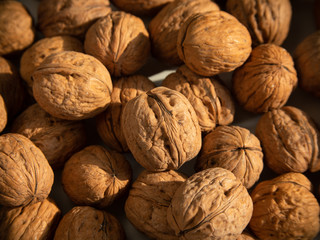 Walnut background, scattered pile of walnuts.